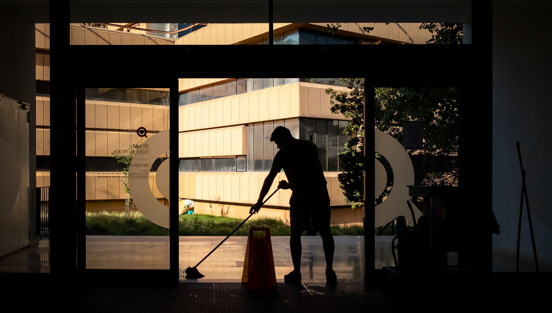 Professional cleaner polishing glass in a bright commercial office